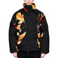 A person with short blond hair wears the ADIDAS x Y-3 KA2364 M AOP Puff JKT in Multco/Black, a black polyamide jacket with a bold orange and yellow abstract floral pattern, standing against a plain white background.