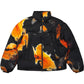 The ADIDAS x Y-3 KA2364 M AOP Puff JKT Multco/Black is a black polyamide puffer jacket with an abstract orange-yellow flame pattern, shown flat with a front zipper and two vertical front pockets.