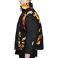 A person with short blond hair stands in profile, wearing ADIDAS x Y-3’s Y-3 KA2364 M AOP Puff JKT Multco/Black—a black puffer jacket with an abstract orange and yellow pattern—and black pants.