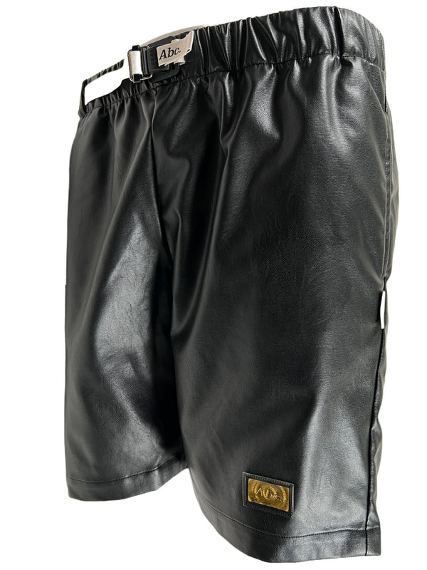 A black ADVISORY BOARD CRYSTALS faux leather work shorts with a buckle.