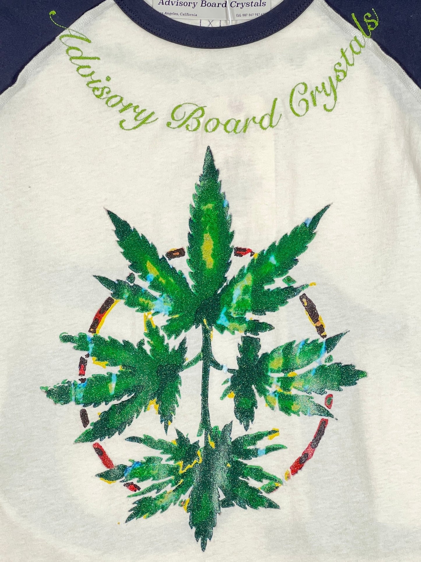 A ADVISORY BOARD CRYSTALS 100% cotton t-shirt with a marijuana leaf on it.