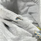 Close-up of a gray fabric with a small tear near a blue and white braided cord, reminiscent of the thick rope texture lace detail found on a grey AL AIN AHOX S150 YACHT LIMITED hoodie.