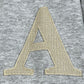 Close-up of a large, embroidered letter "A" in beige thread on a textured, grey AL AIN AHOX S150 YACHT LIMITED hoodie fabric background.