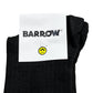 These Barrow S4BWUASO140 unisex socks feature a black design with a white label displaying the word "BARROW" and a yellow smiling face with black eyes and mouth. Expertly made in Italy, these socks exemplify impeccable quality.