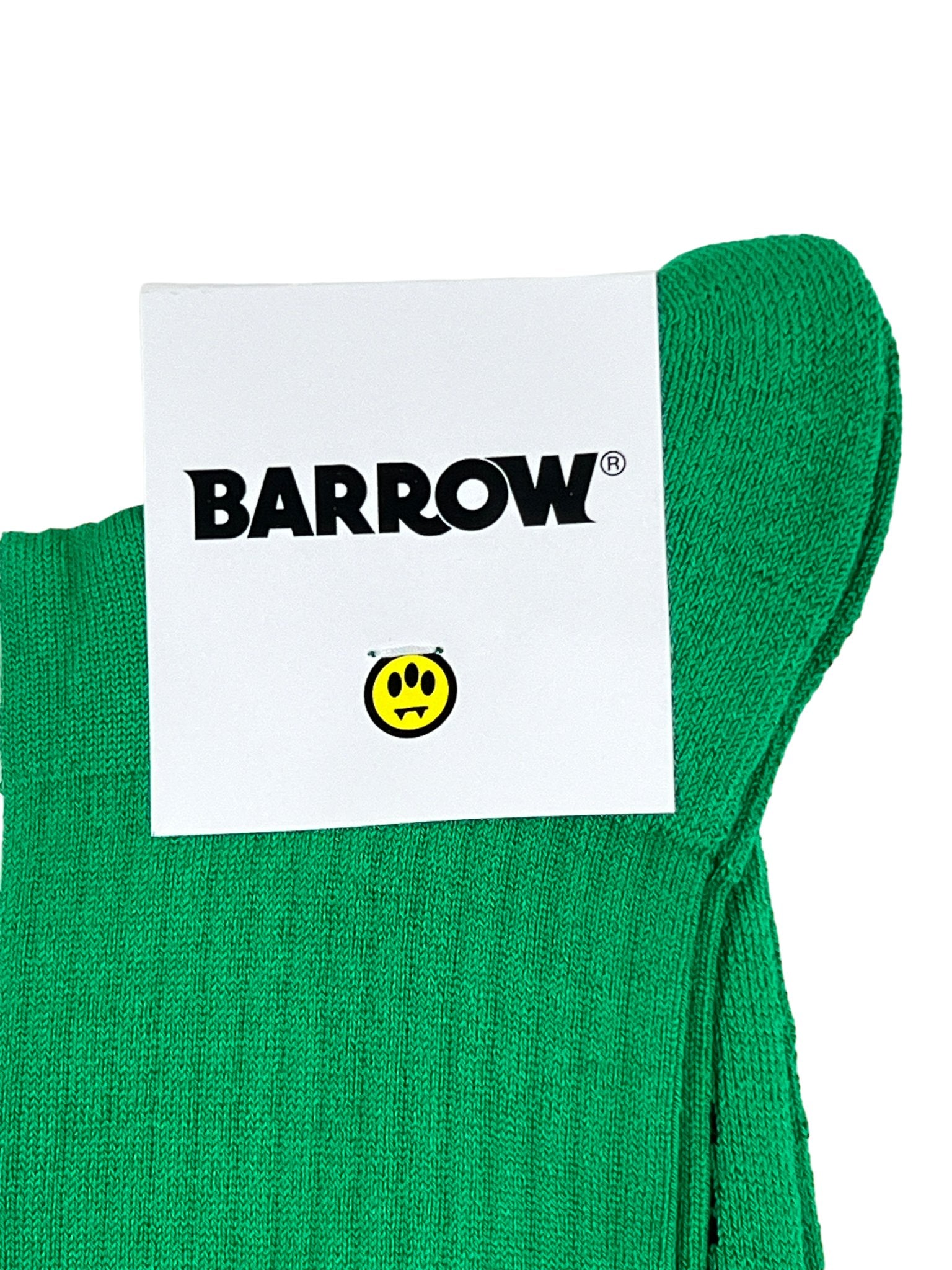 A green towel adorned with a prominent BARROW brand label and a small, cheerful yellow smiley face icon. Expertly crafted with the same attention to detail as our distinctive Barrow S4BWUASO140 unisex socks made in Italy, it introduces a playful yet elegant flair to your bathroom collection.
