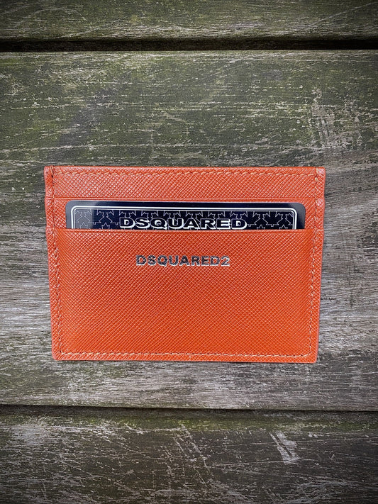 A DSQUARED2 CCM0005 CARD HOLDER SAFFIANO ARANCIO sitting on a wooden table.