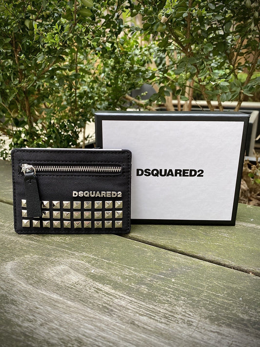 A small black DSQUARED2 CCM0006 card holder borchia to nero with silver studs on a wooden surface.