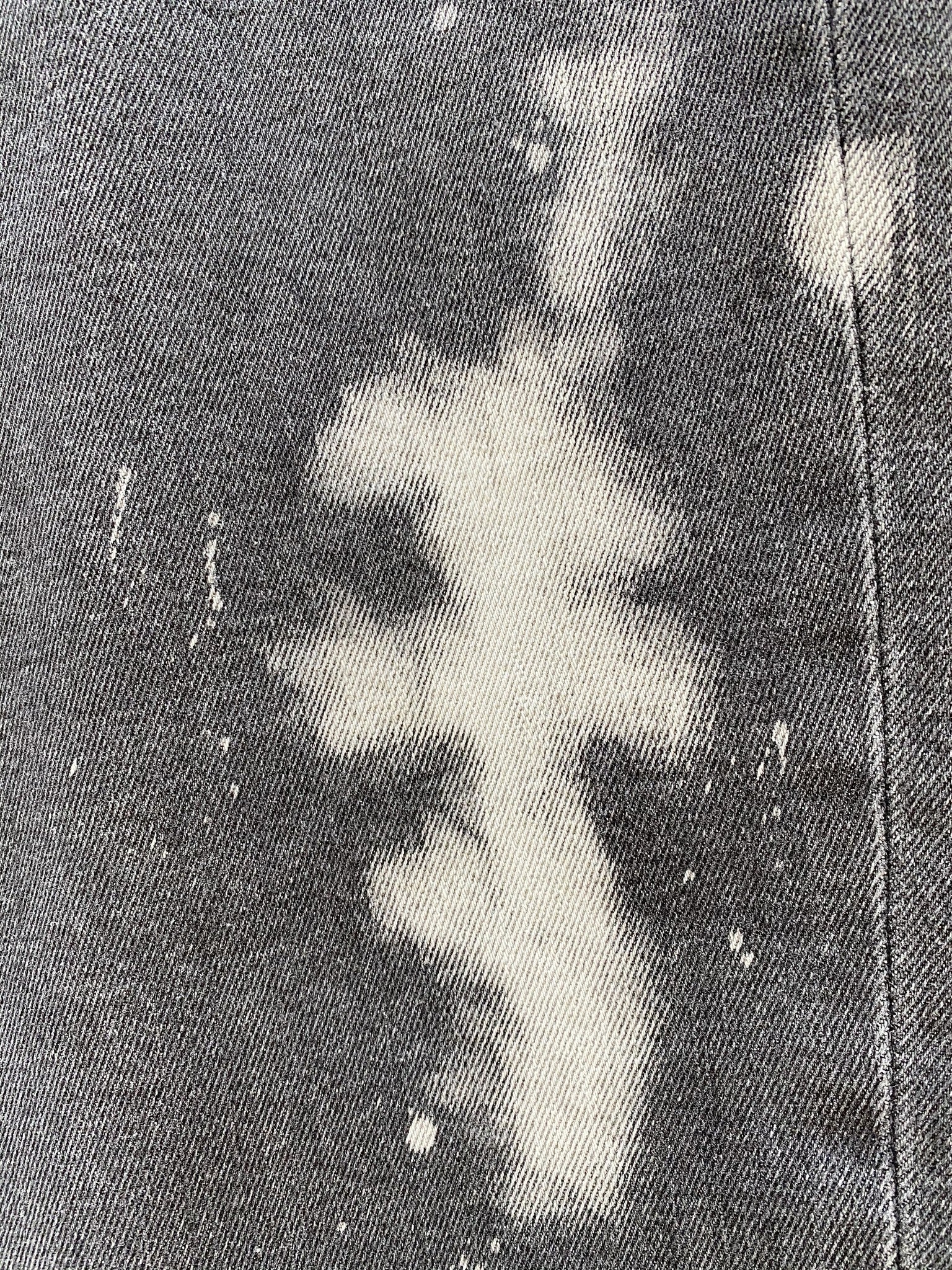 Close-up of a fabric with a white abstract pattern resembling a cross on a dark background, reminiscent of the intricate designs seen on the Diesel D-Strukt-SP17 09RE jeans by DIESEL.