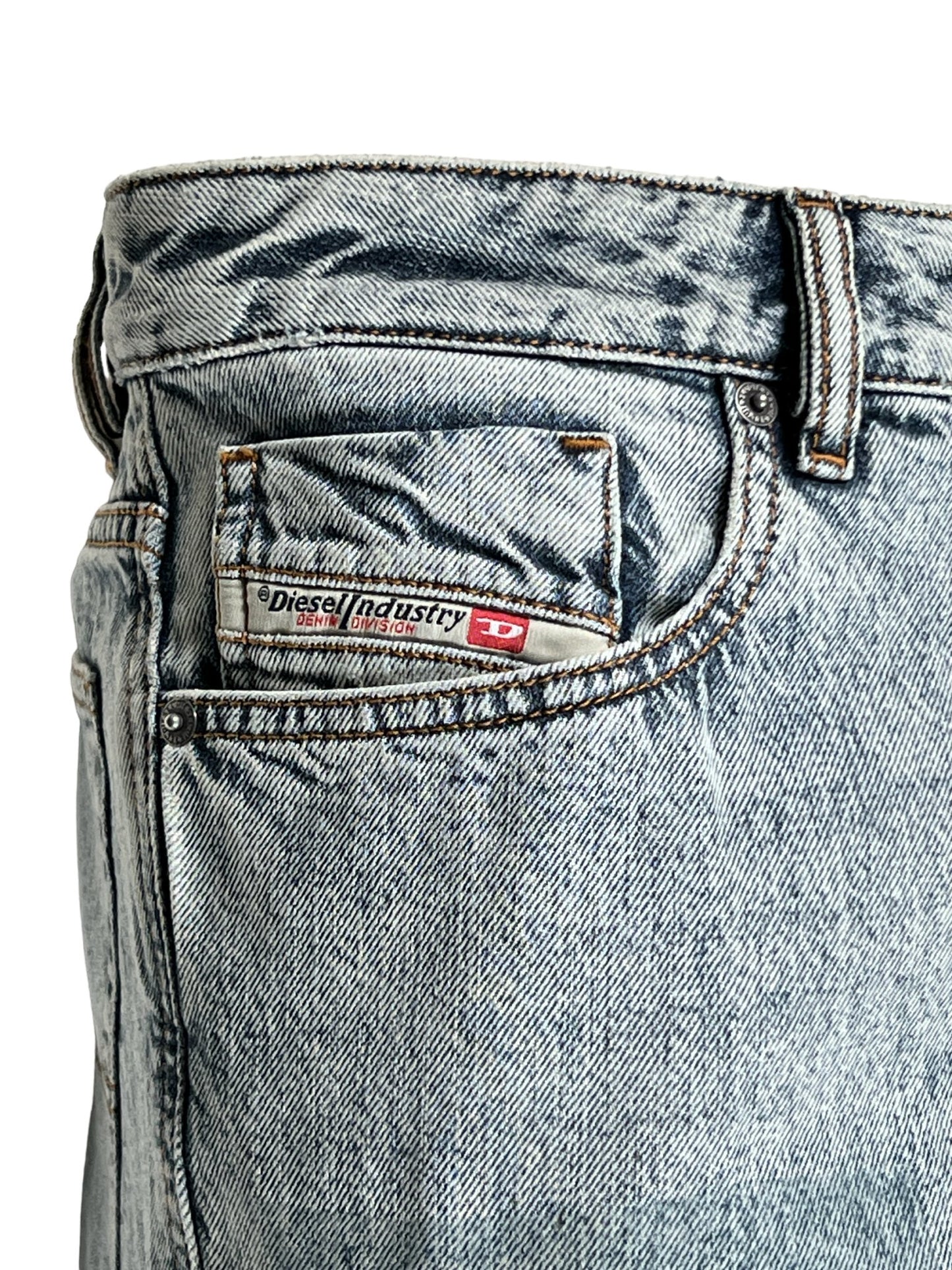 Close-up of a light wash denim jean's waistband featuring a DIESEL 1955 D-REKIV-S1 9160 DENIM brand label.