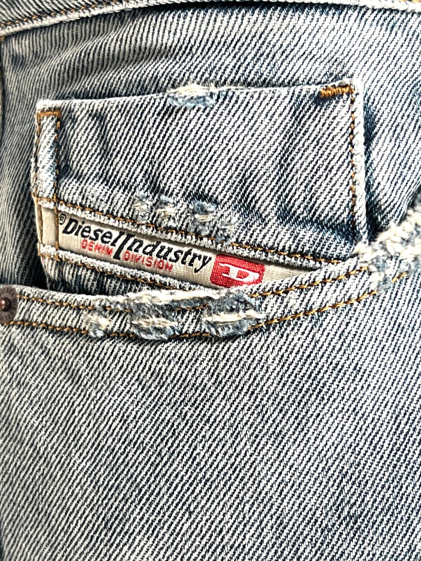 A close up of the pocket of a pair of DIESEL light blue 1955 jeans 9C90.