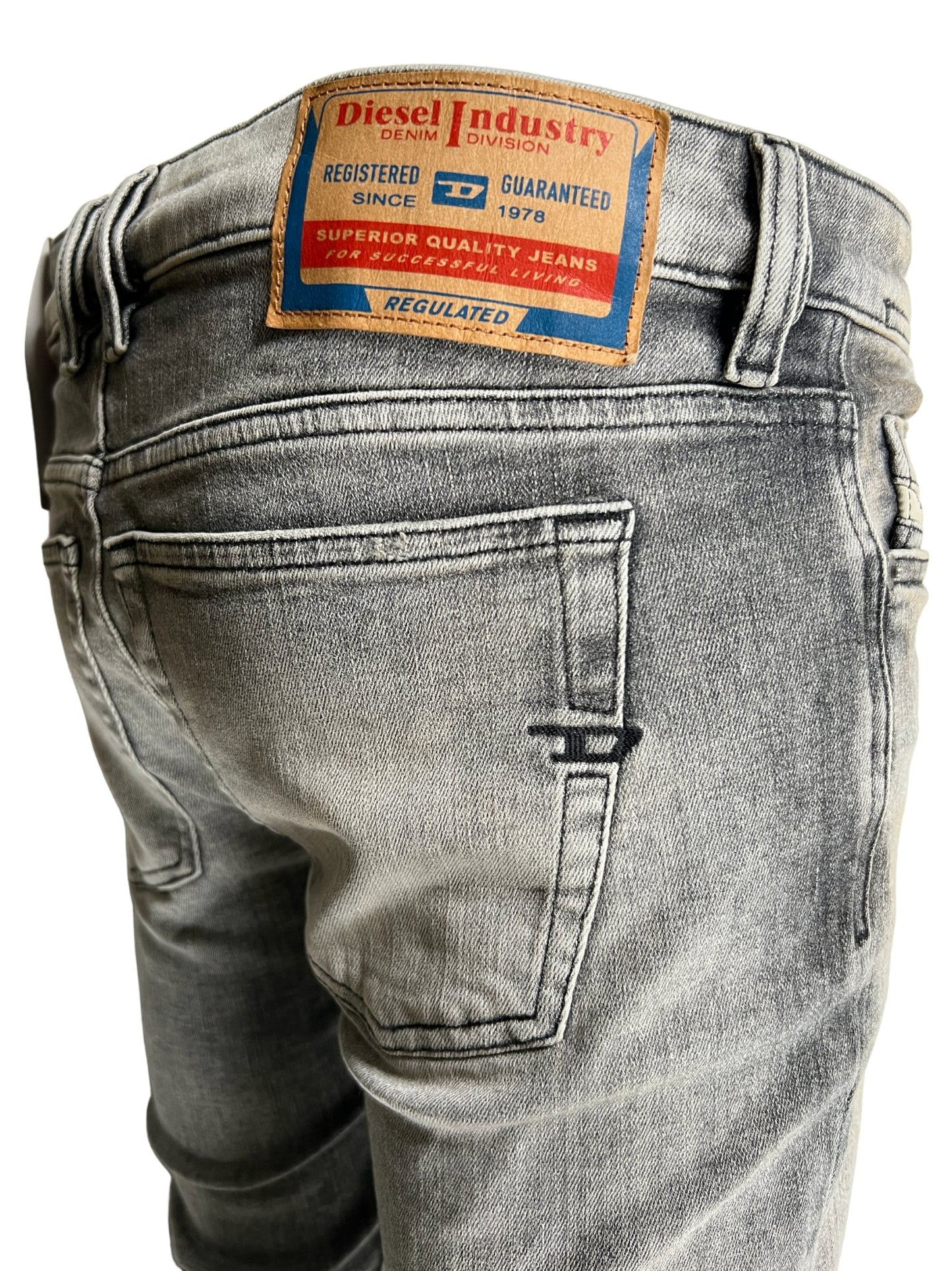 Close-up of the back of a pair of DIESEL brand skinny jeans showing the label and pocket detail.