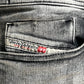 Close-up of a gray pocket from the Diesel 1979 Sleenker 9H74 stretch denim jeans, featuring a label with "Diesel Industry" in red and black text.
