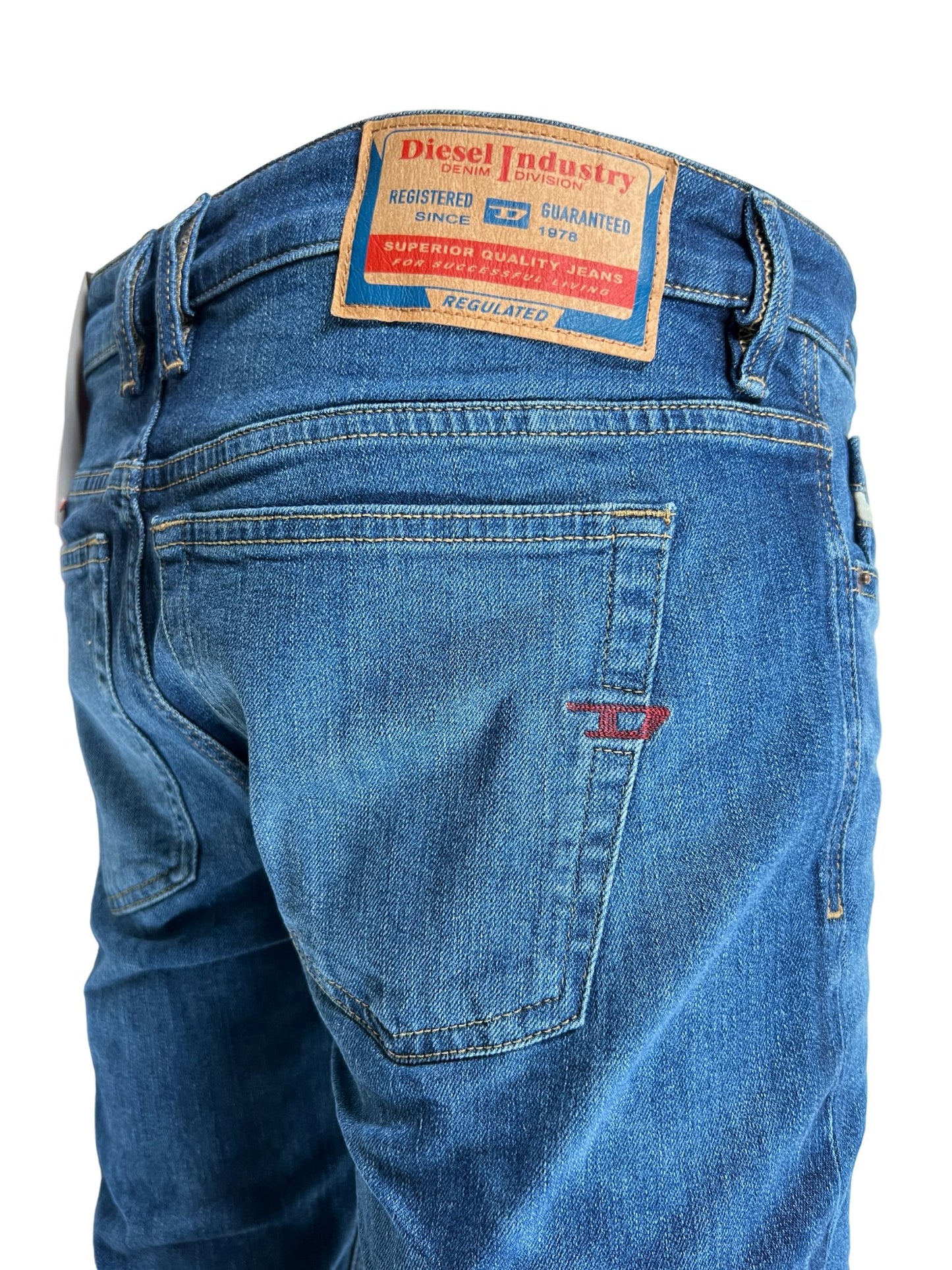 A pair of DIESEL skinny style blue jeans with a label on the back.