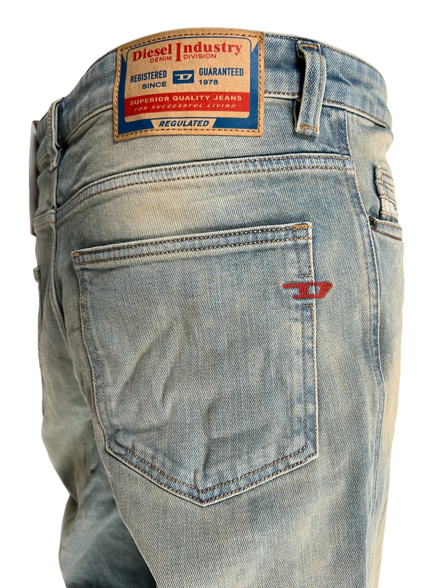 Close-up of the back pocket and waistband label on a pair of DIESEL bootcut jeans.