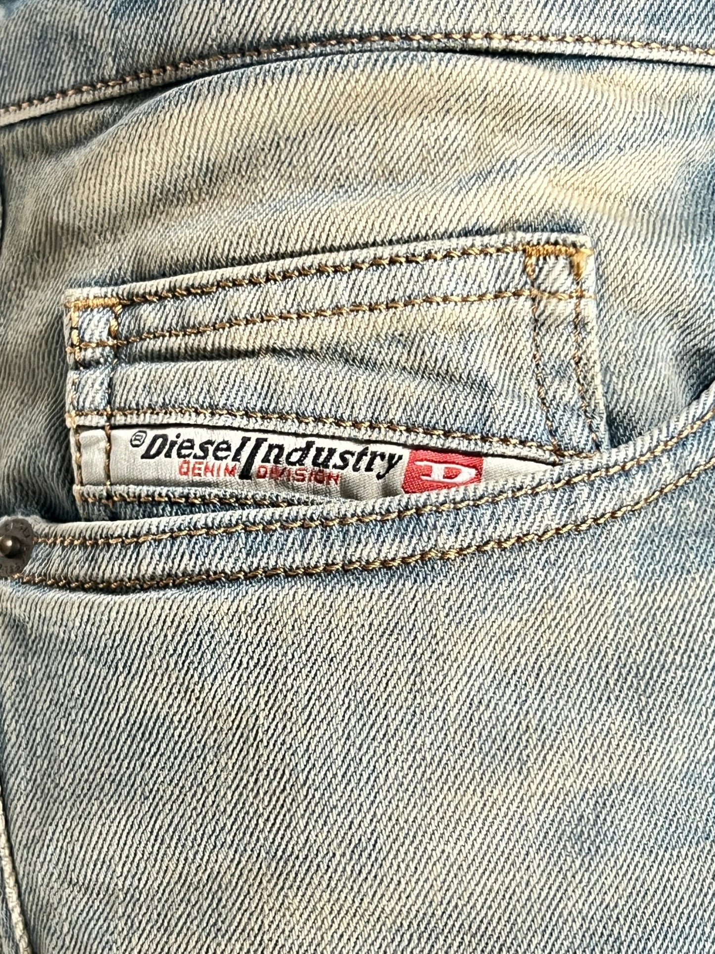 Close-up of DIESEL 1998 D-BUCK 9H78 bootcut jeans crafted from Better Cotton, showcasing the comfort denim with a brand label.
