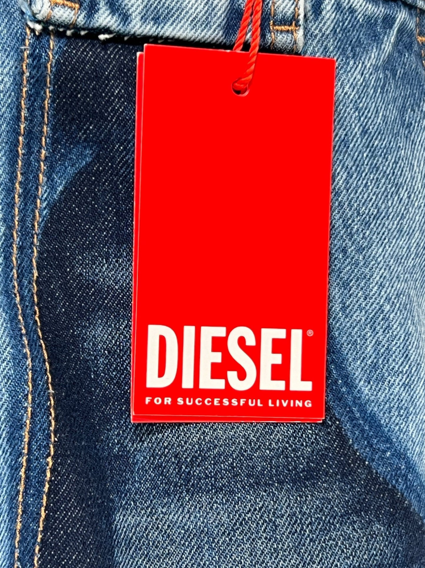 Red DIESEL brand tag attached to a pair of light blue DIESEL D-P-5-D-S jeans.