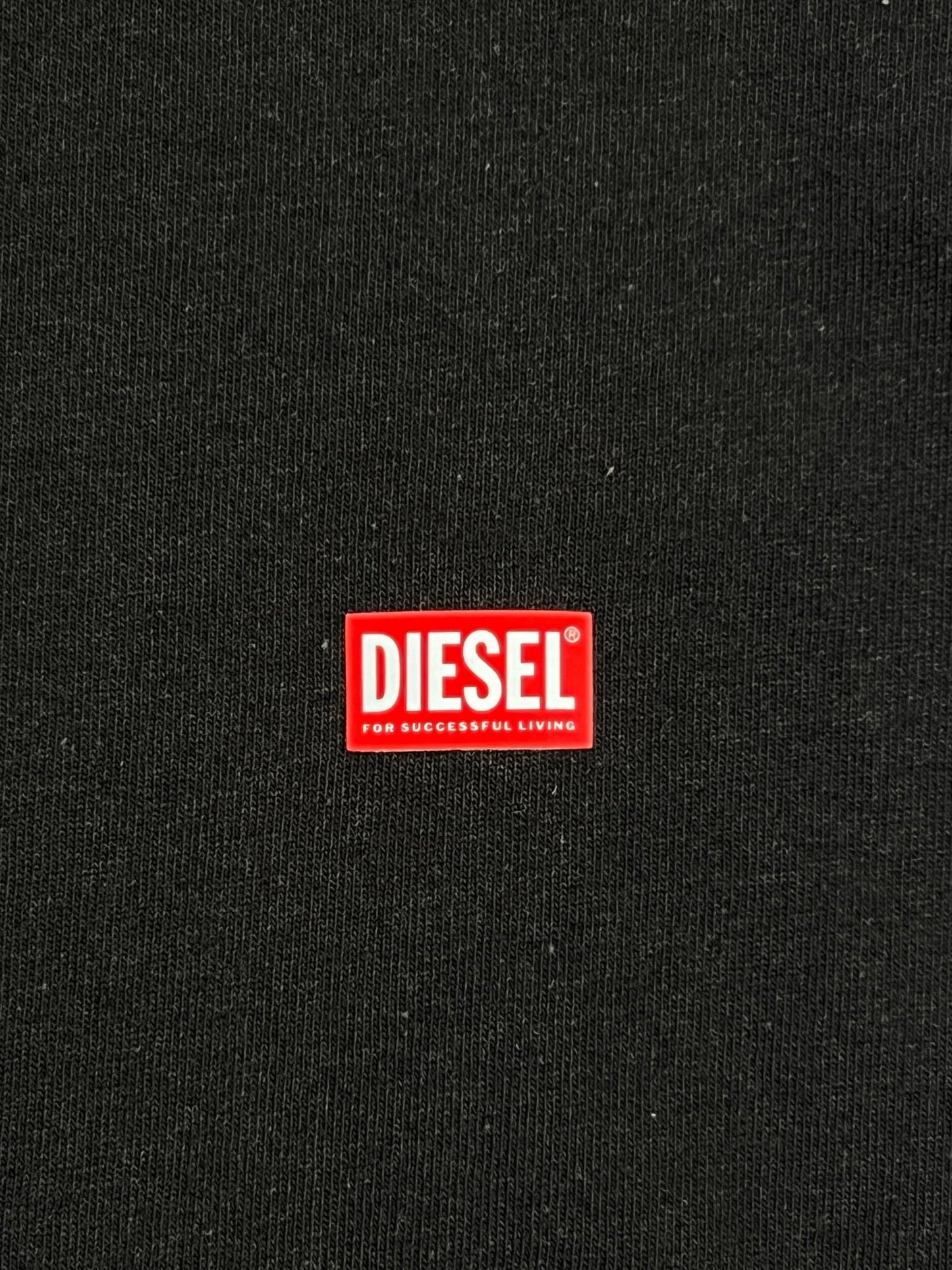 A close up of a distressed-effect DIESEL logo on a DIESEL T-BOXT-N11 T-SHIRT BLACK.