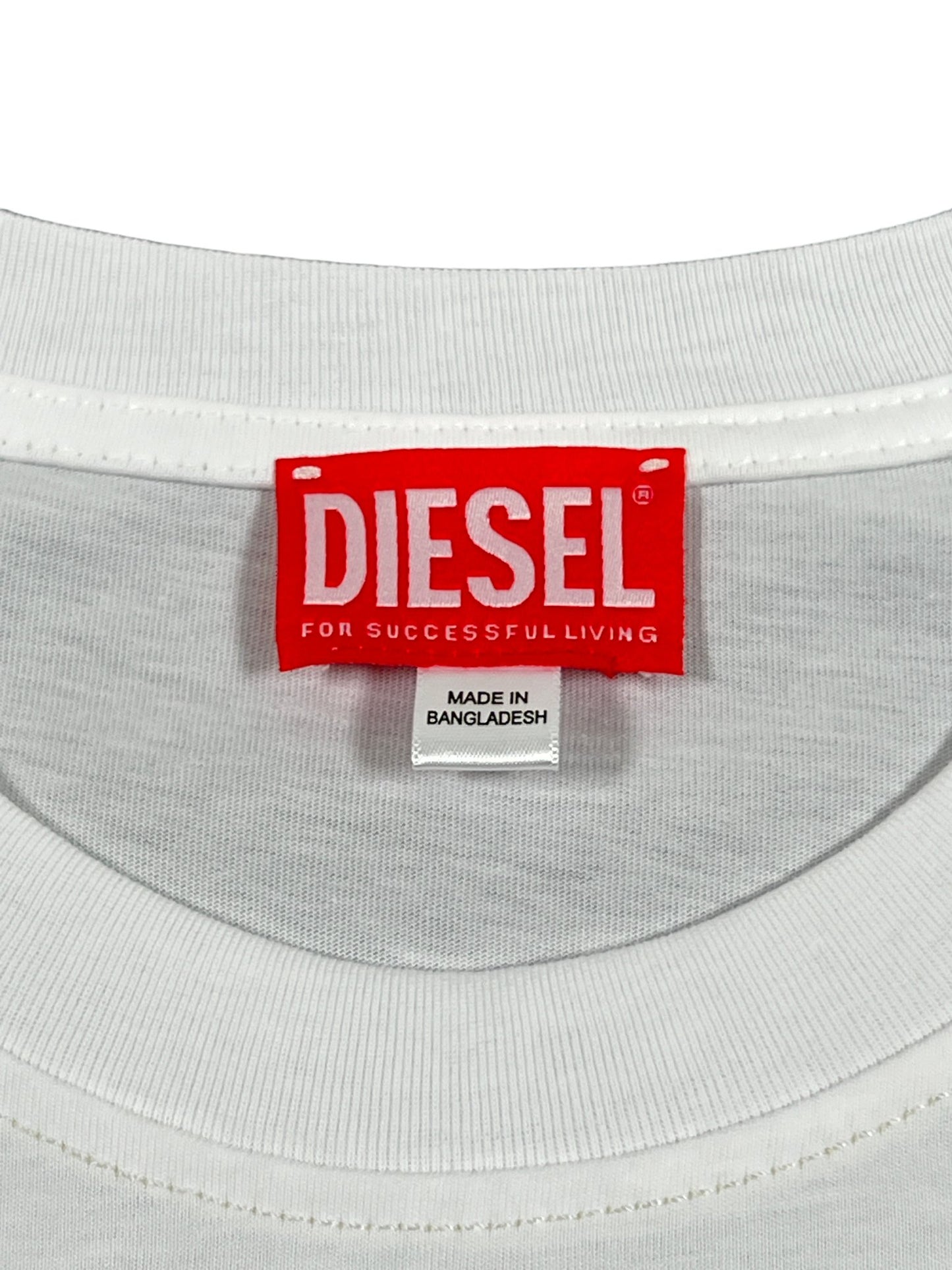 Close-up of a white DIESEL T-DIEGOR-K74 T-SHIRT label indicating it is made in Bangladesh and crafted from organic cotton jersey.