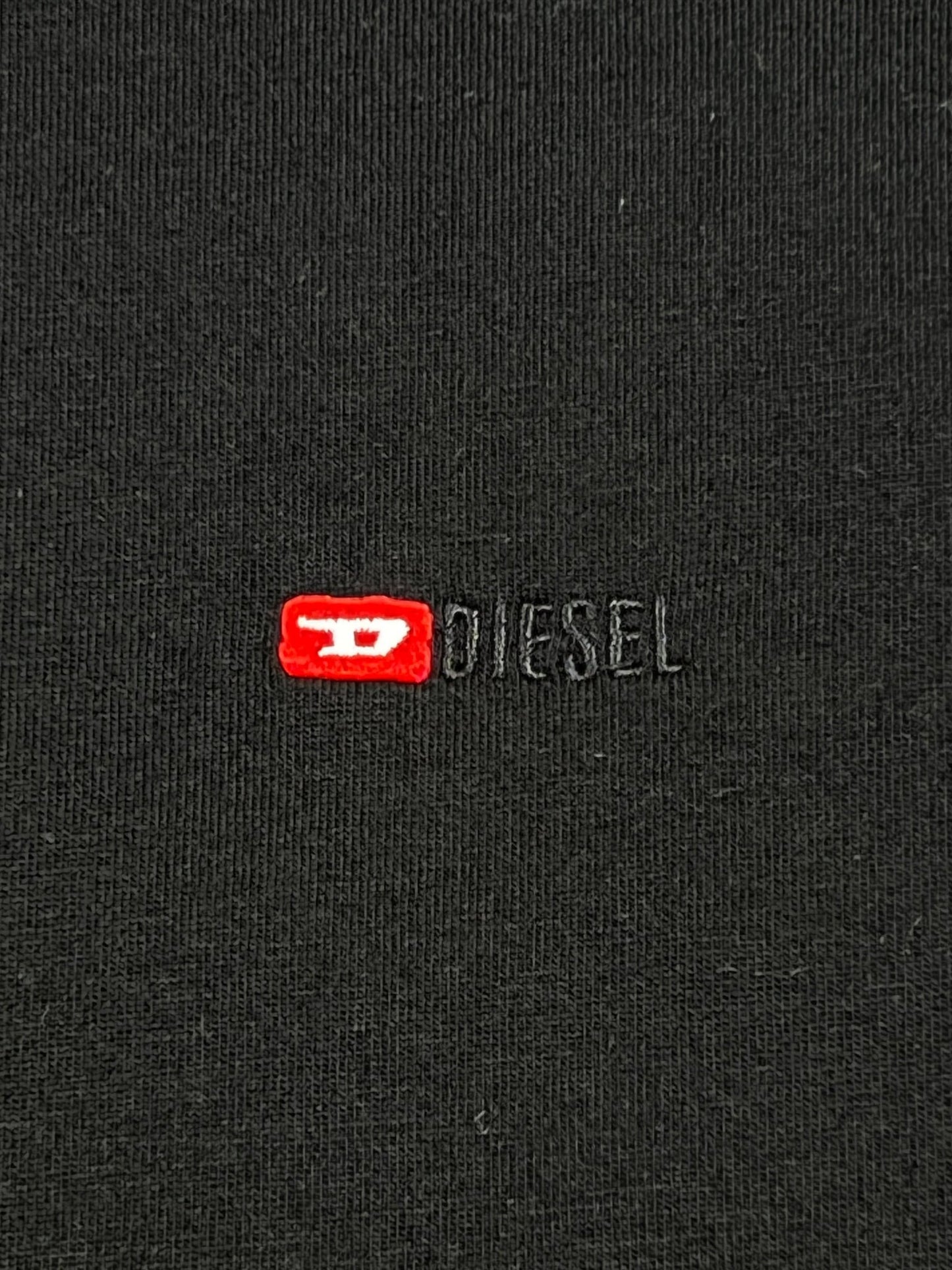 A close-up of a black cotton DIESEL T-JUST-MICRODIV T-SHIRT with the logo "Diesel" on it.