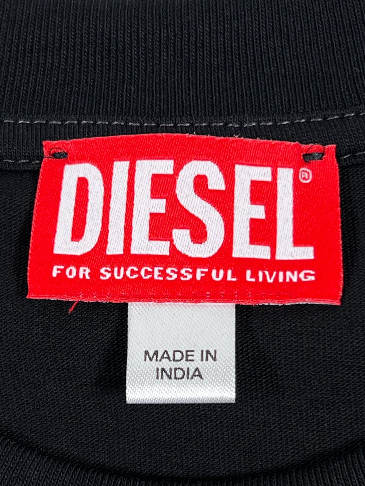 Red and white iconic Diesel logos brand label on a black textile background with a "made in India" tag below.