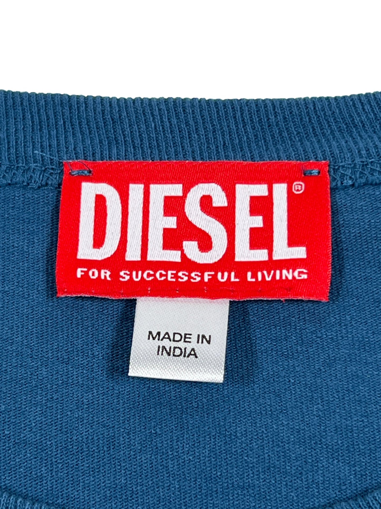 Red and white DIESEL T-RUST t-shirt label on clothing with a smaller 'made in India' tag below it, crafted from 100% Cotton in a Regular Fit.