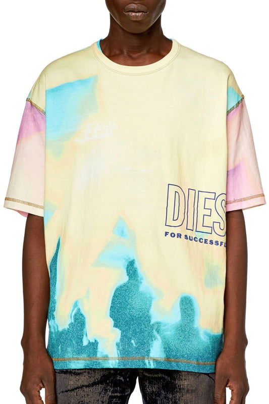 A man wearing a DIESEL T-WASH-COLOR T-SHIRT YELLOW with a graphic print Diesel logo that says dies for success.