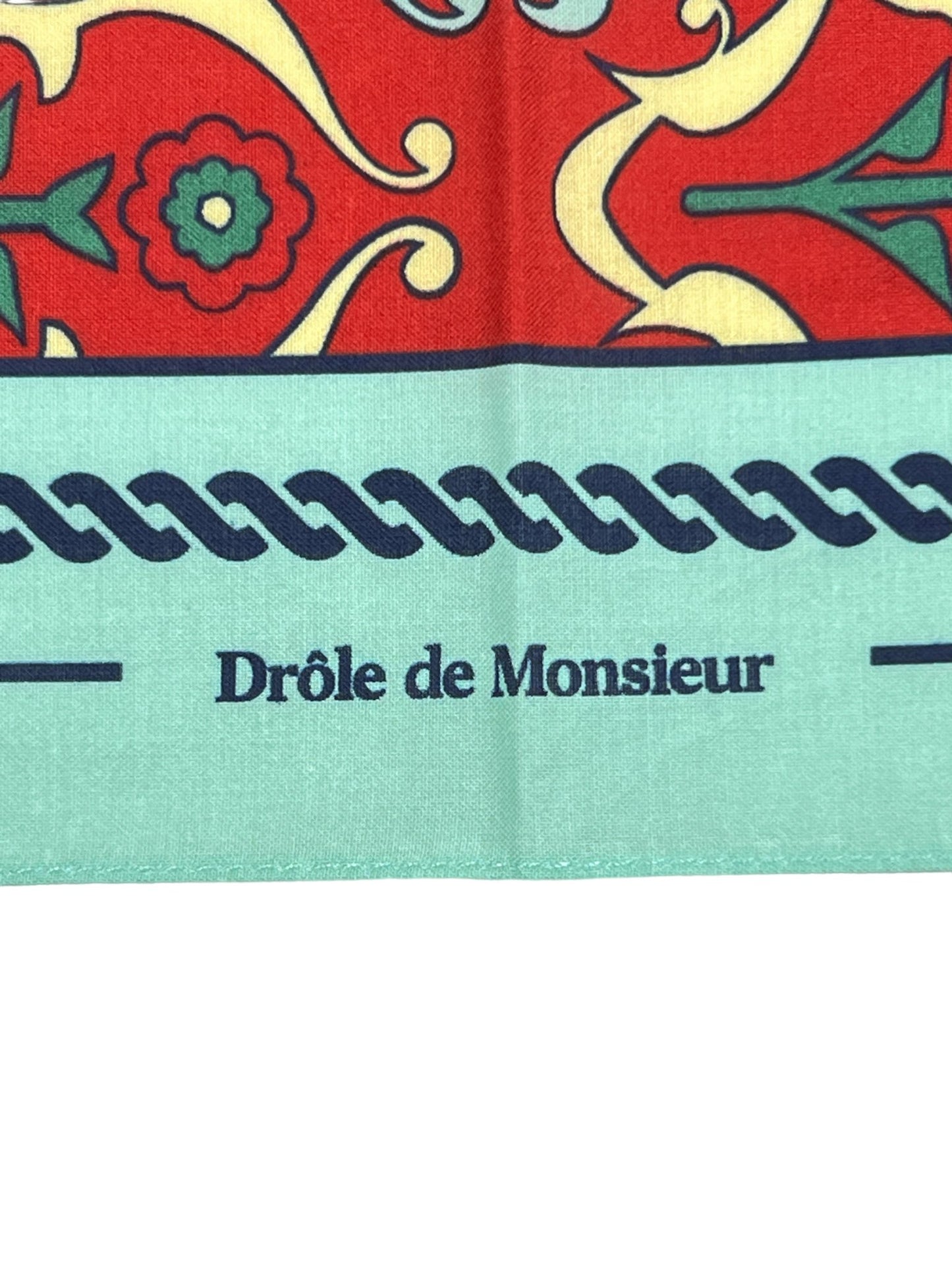 Red and teal DROLE DE MONSIEUR D-BA002-CO128-RD LE FOULARD ORNEMENTS scarf printed with the text "drôle de monsieur" and an ornaments pattern.
