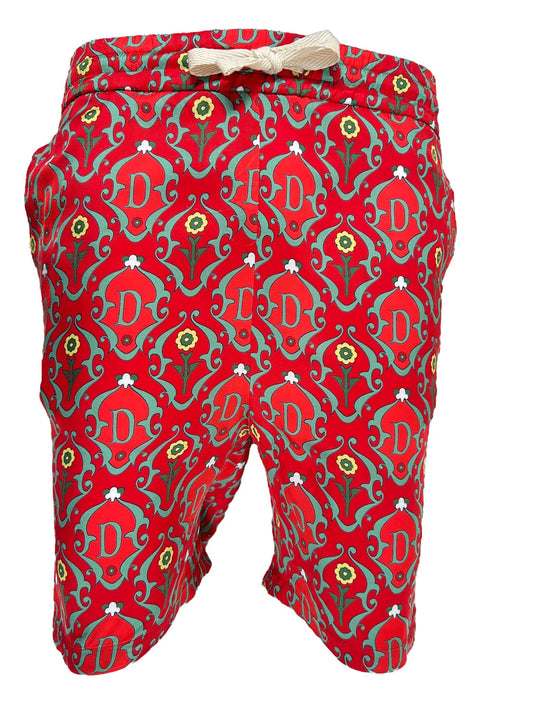 A DROLE DE MONSIEUR red swim shorts with a green and red all-over print pattern.