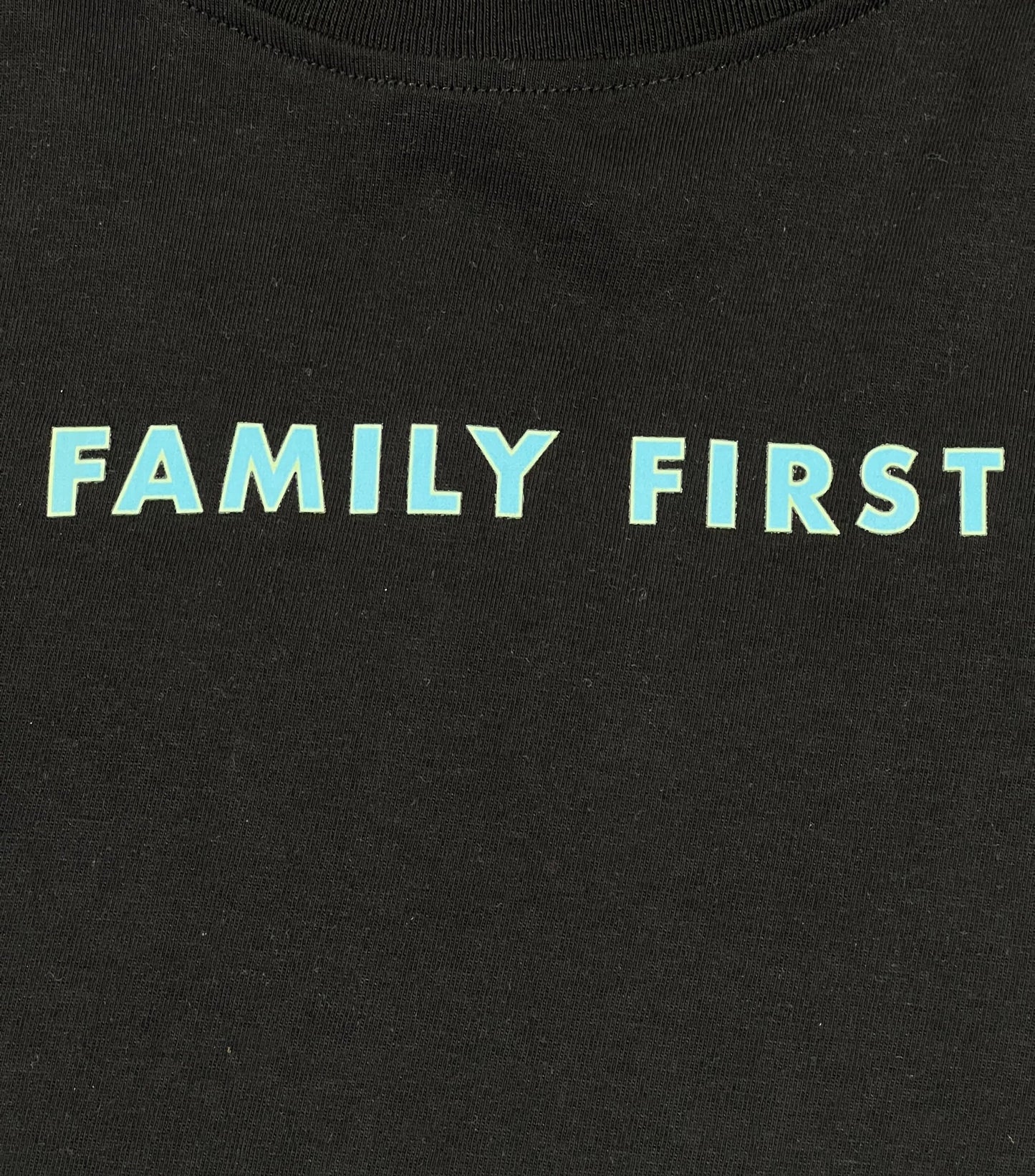 A black graphic FAMILY FIRST t-shirt with the word "family first" on it, made from 100% cotton.