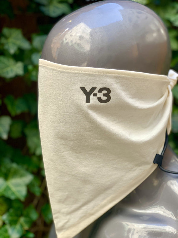A mannequin wearing a Y-3 HA1336 Reflective Bandana White with the word ADIDAS x Y-3 on it.