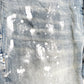 Close-up of Purple Brand Jeans P001-LIA in light indigo, showcasing white paint splatters on the denim fabric and a fashionably worn appearance that echoes PURPLE BRAND's iconic ripped jeans style.