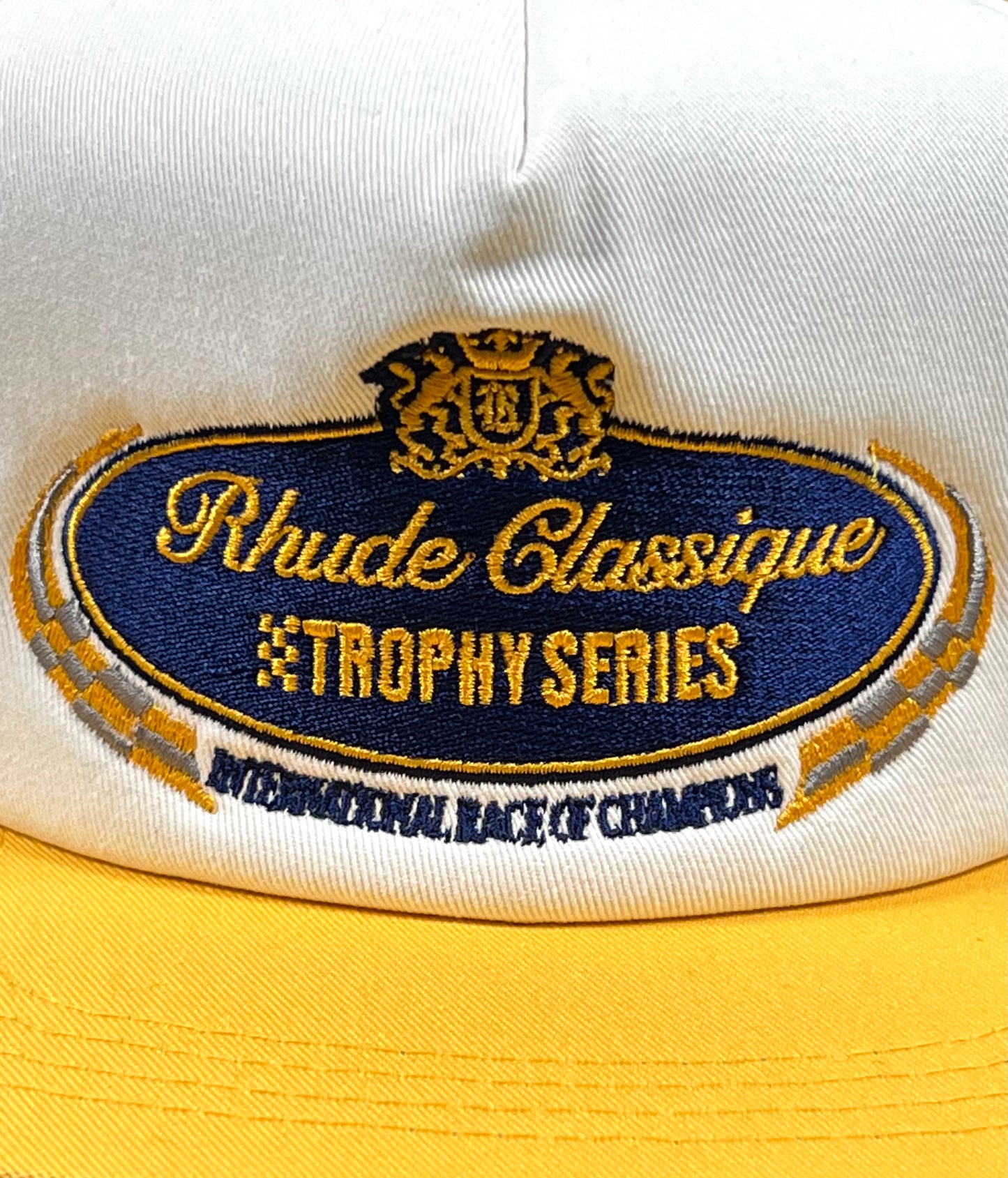 A hat with an adjustable strapback and embroidered branding that says Rhude Trophy Series.