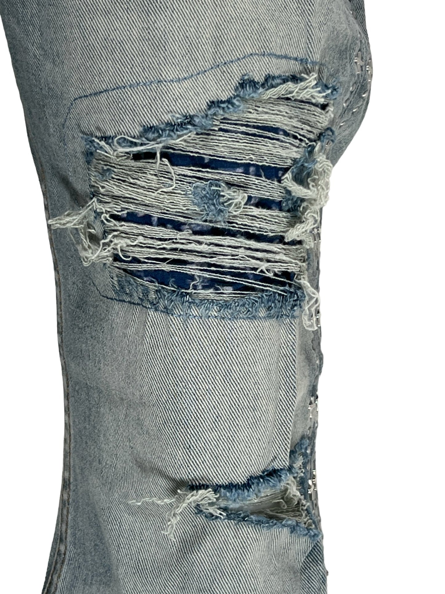 Close-up of distressed Ksubi Bronko Dynamite Metal denim fabric with frayed holes and threads.