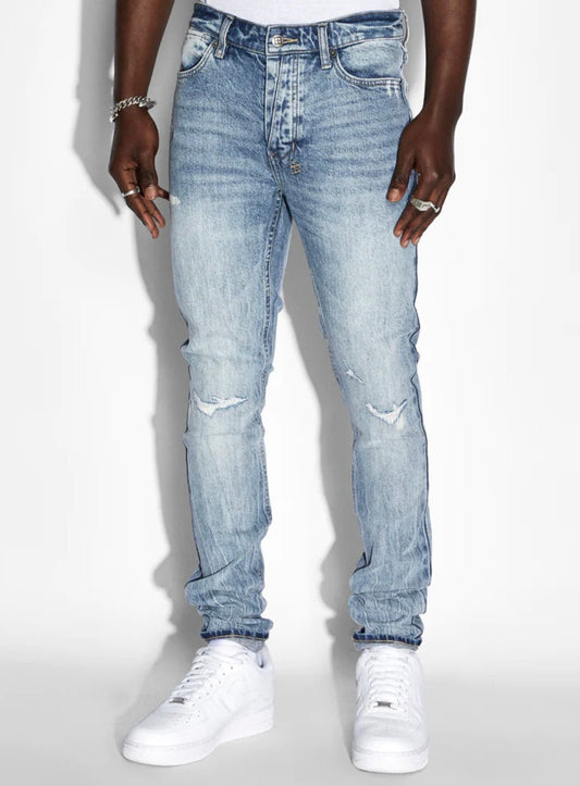 A black man wearing ripped Ksubi brand skinny fit jeans, the Ksubi Van Winkle Highfly Denim, and a white t-shirt.