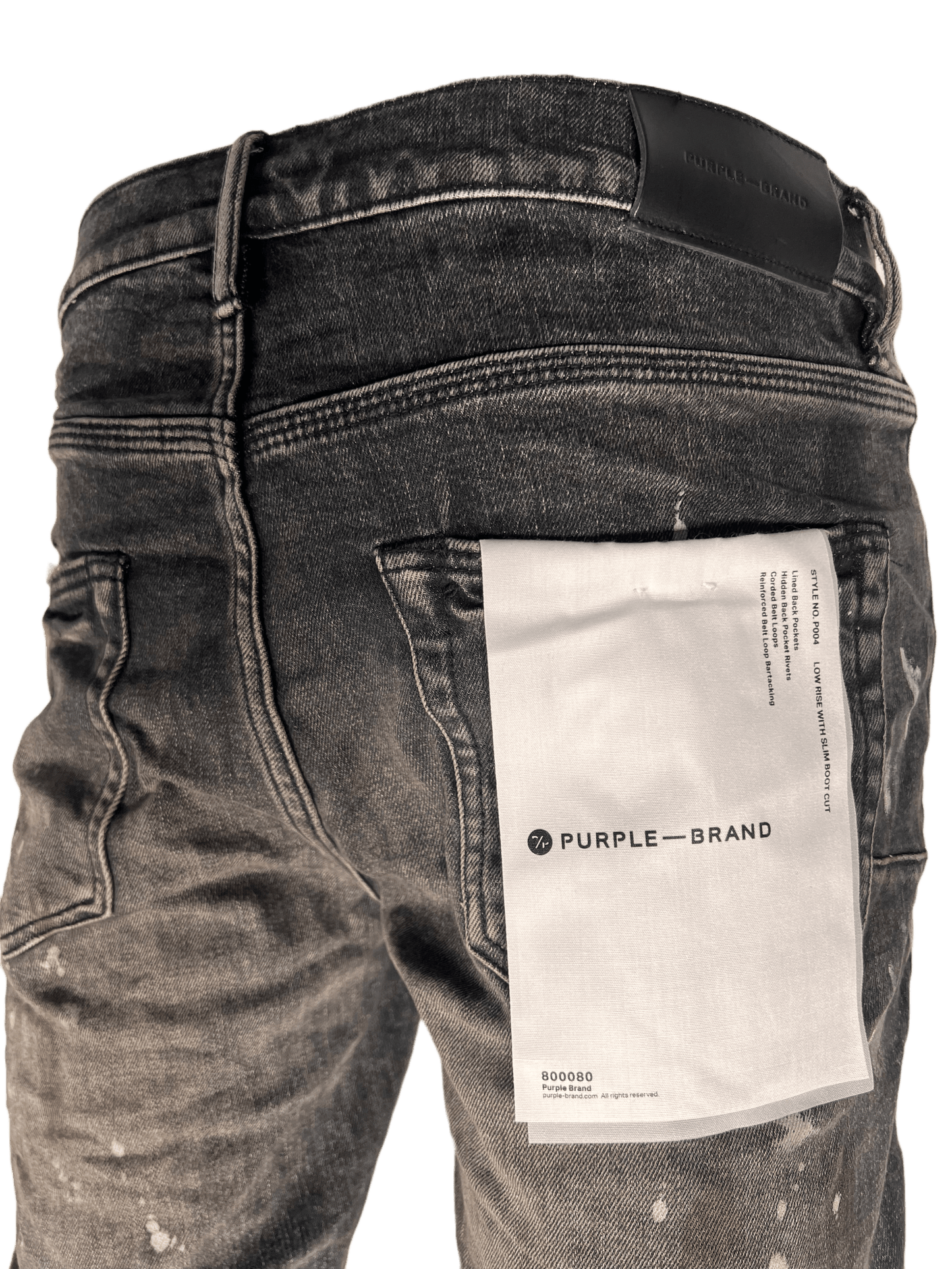 A pair of PURPLE BRAND boot cut denim jeans with a paper in the pocket.
