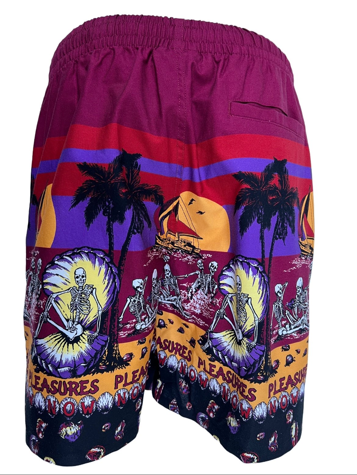 A PLEASURES swim shorts with palm trees print on it.