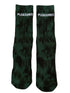 The Pleasures Indie Dye Socks Hunter feature "PLEASURES" in white text on two green socks, adding edgy style to any outfit.