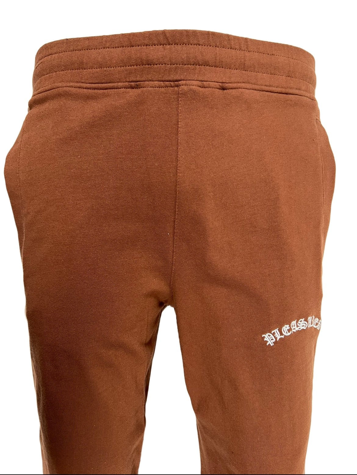 A PLEASURES brown cotton pants with white embroidered leg branding on it.