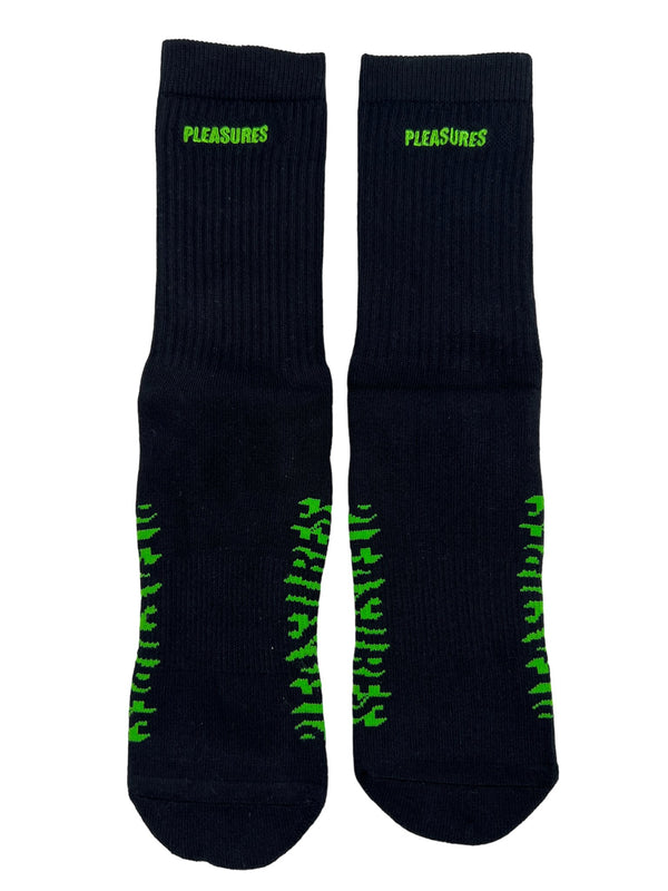 A pair of PLEASURES Knock Out Socks in black with green letters on them.