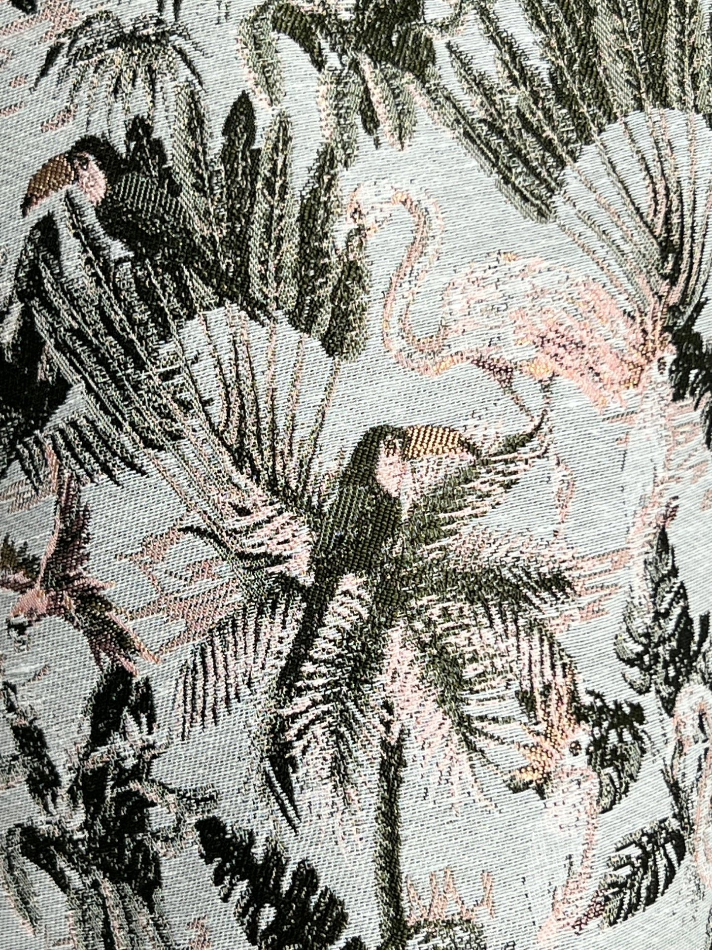 A close up of Pleasures Parrot Shorts Grey with tropical birds and palm trees.