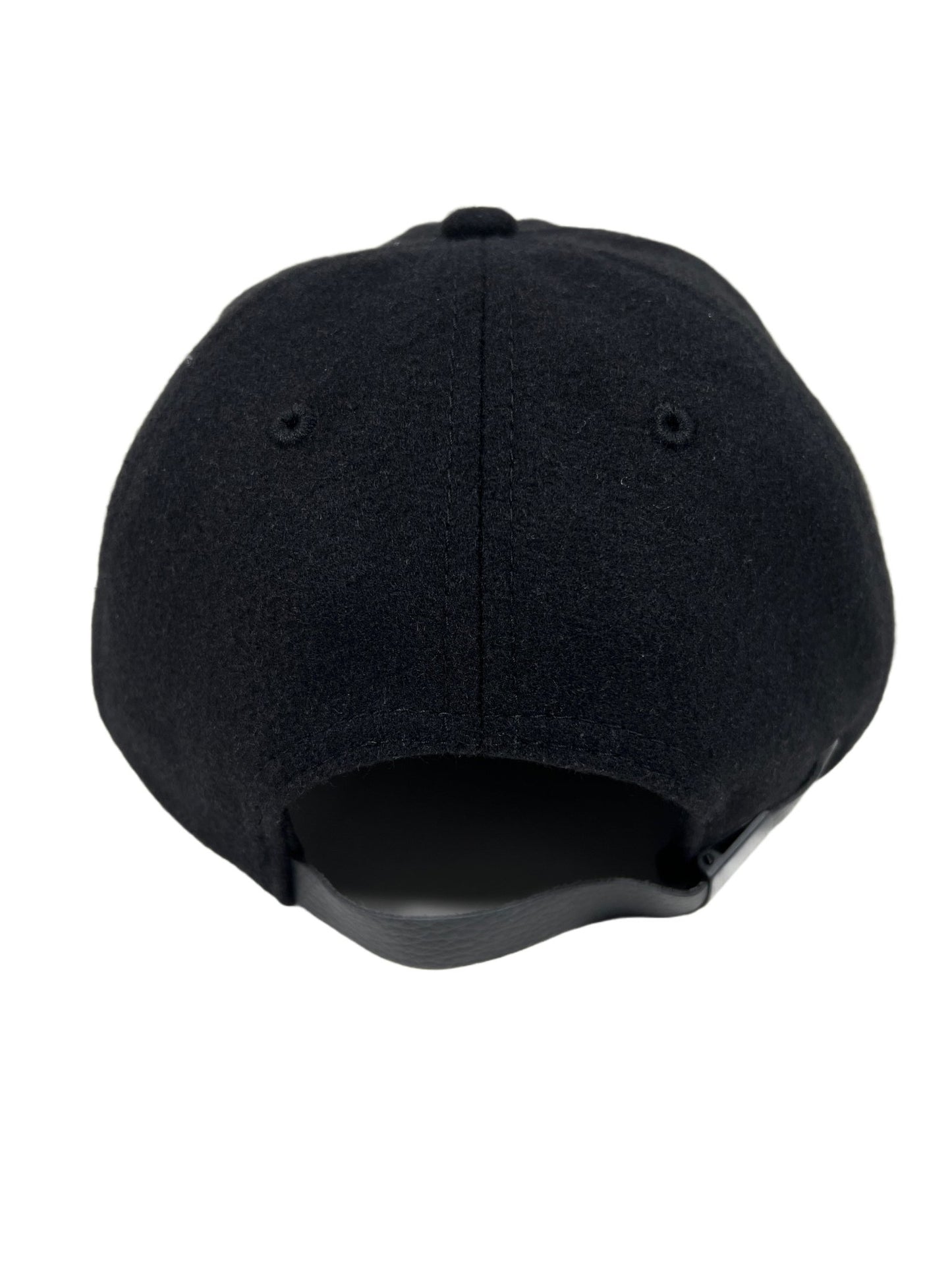 The back view of a black wool hat with a PLEASURES logo.