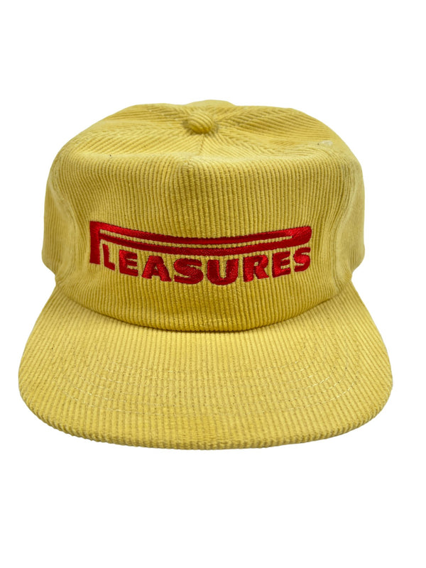A yellow cotton corduroy hat with the word "PLEASURES" embroidered on it.