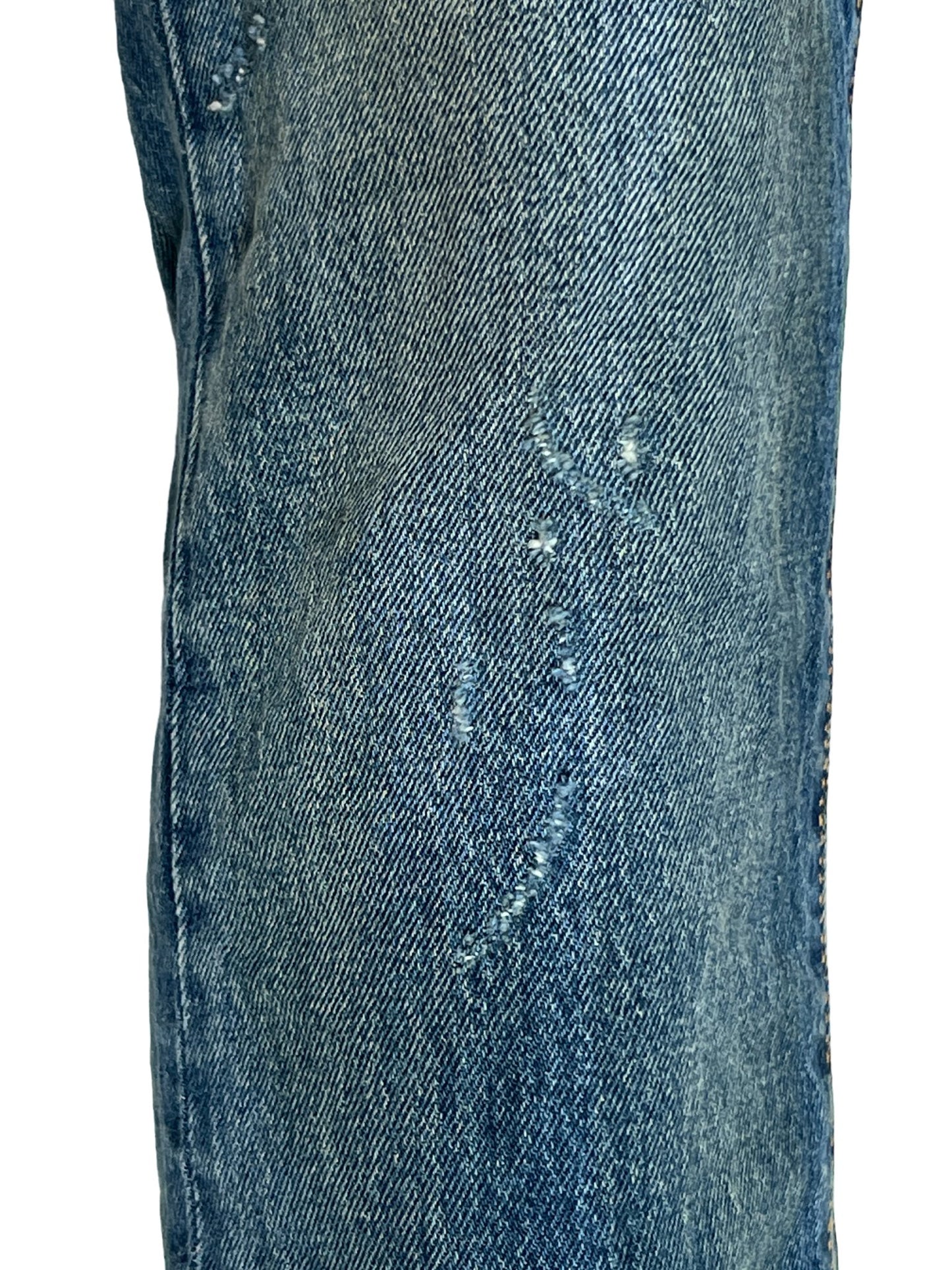 A pair of Purple Brand P001-DPMI Dirty Patina DK Indigo stretch denim jeans with holes in them.