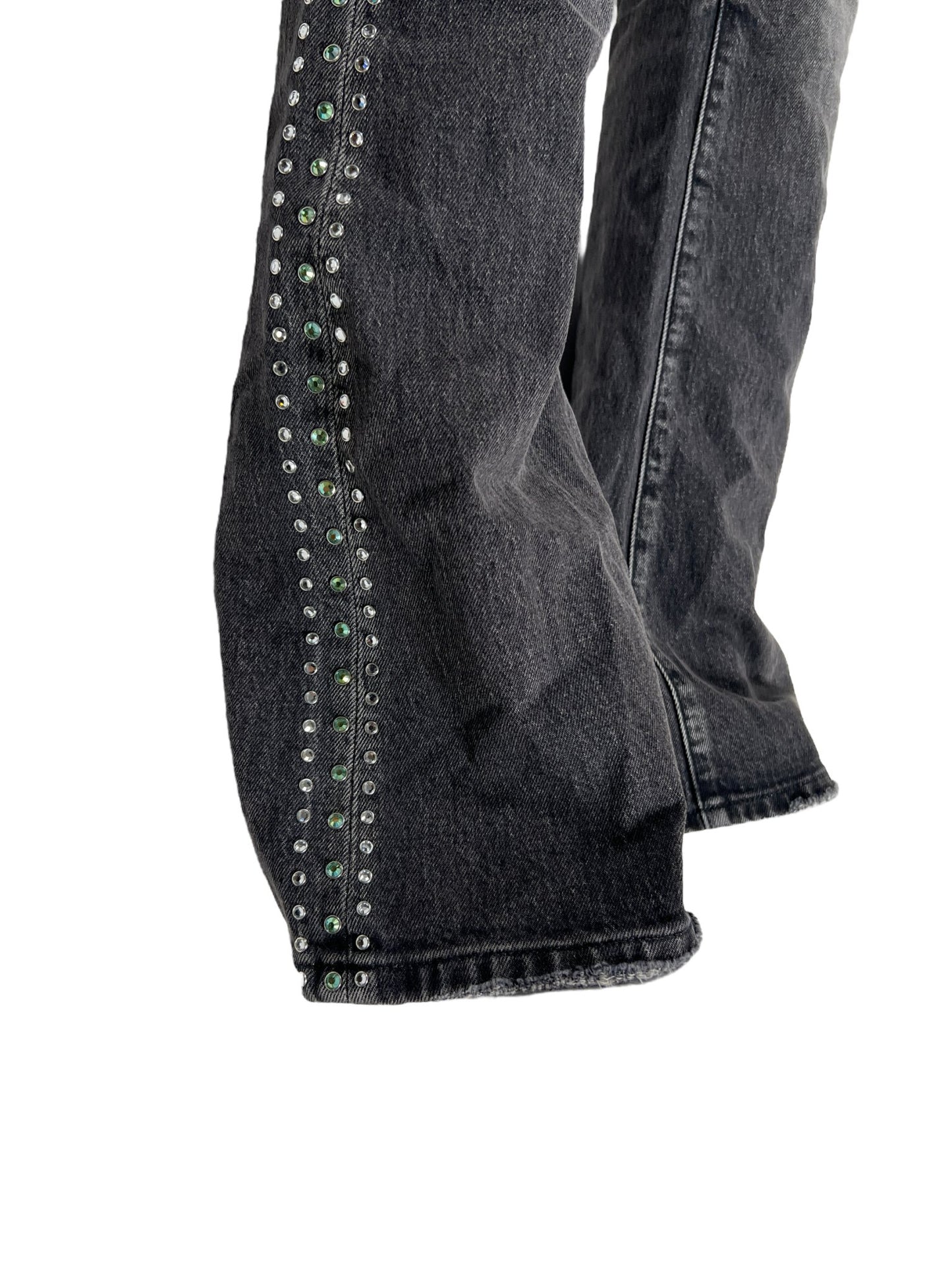 A pair of PURPLE BRAND P004-VNBL VINTAGE FLARE BLACK jeans with green studding on them.