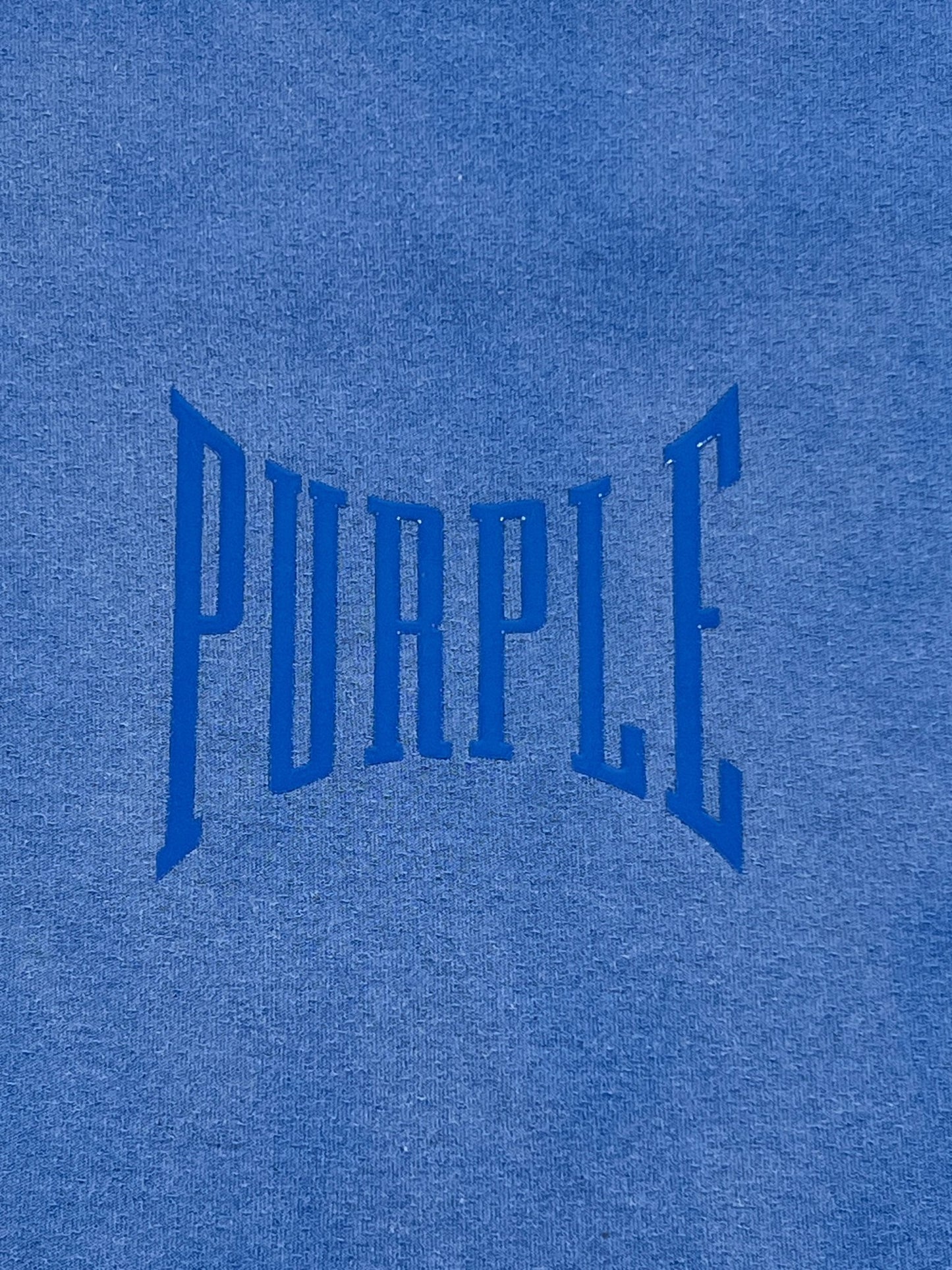 A cotton blue sweatshirt with the word "PURPLE BRAND P101-JUCB TEXTURED INSIDE OUT TEE BLUE" on it.
