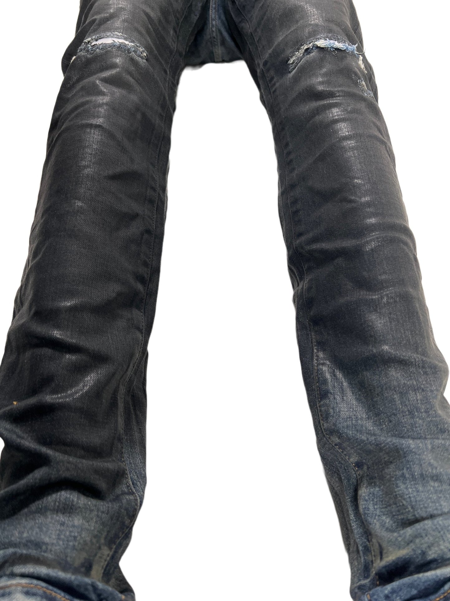 A pair of PURPLE BRAND PURPLE BRAND JEANS P001-IBCG MID INDIGO BLACK COATED GRADIENT with holes in them.