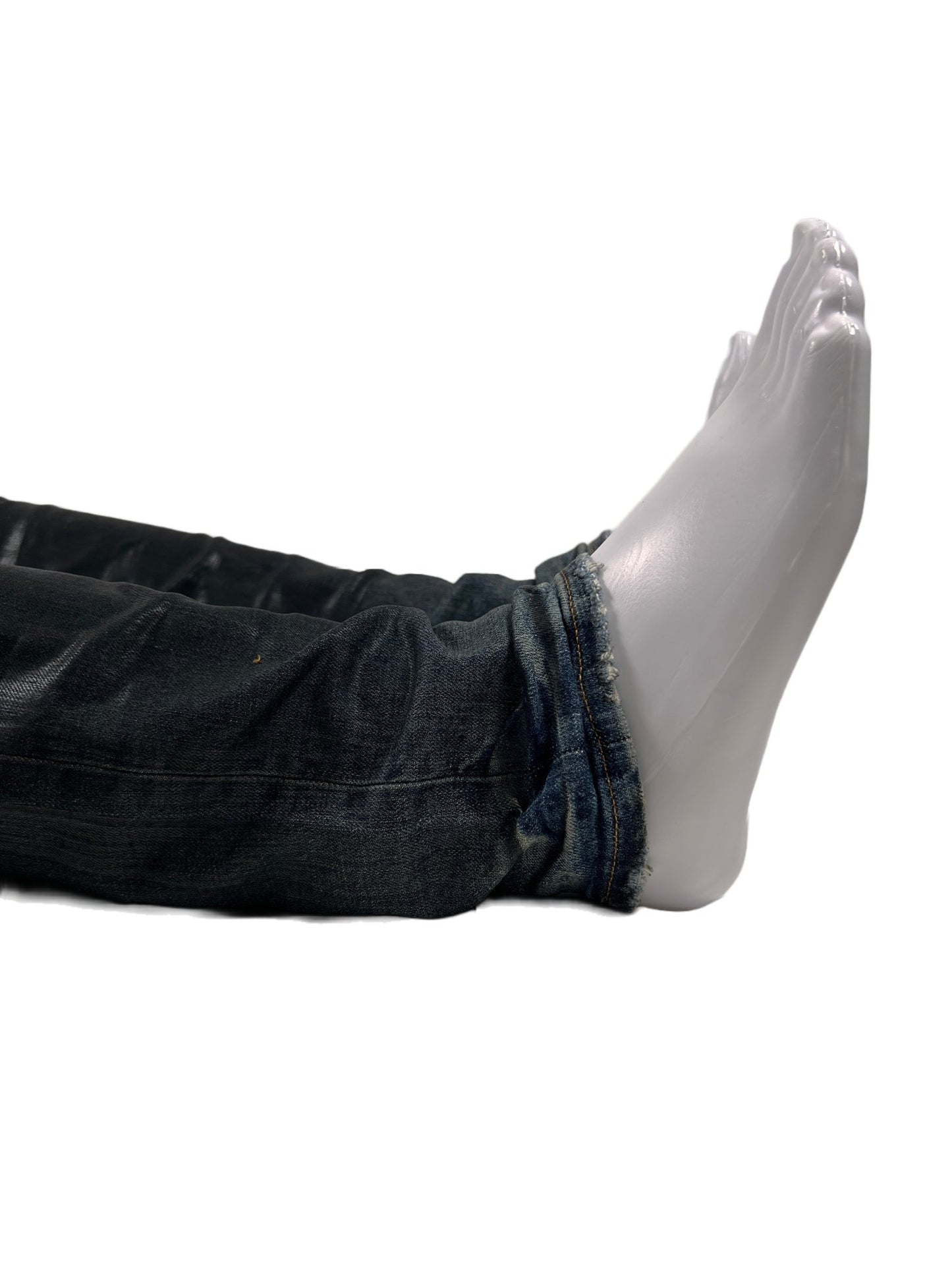 A mannequin laying on a white background with a pair of PURPLE BRAND JEANS P001-IBCG MID INDIGO BLACK COATED GRADIENT.