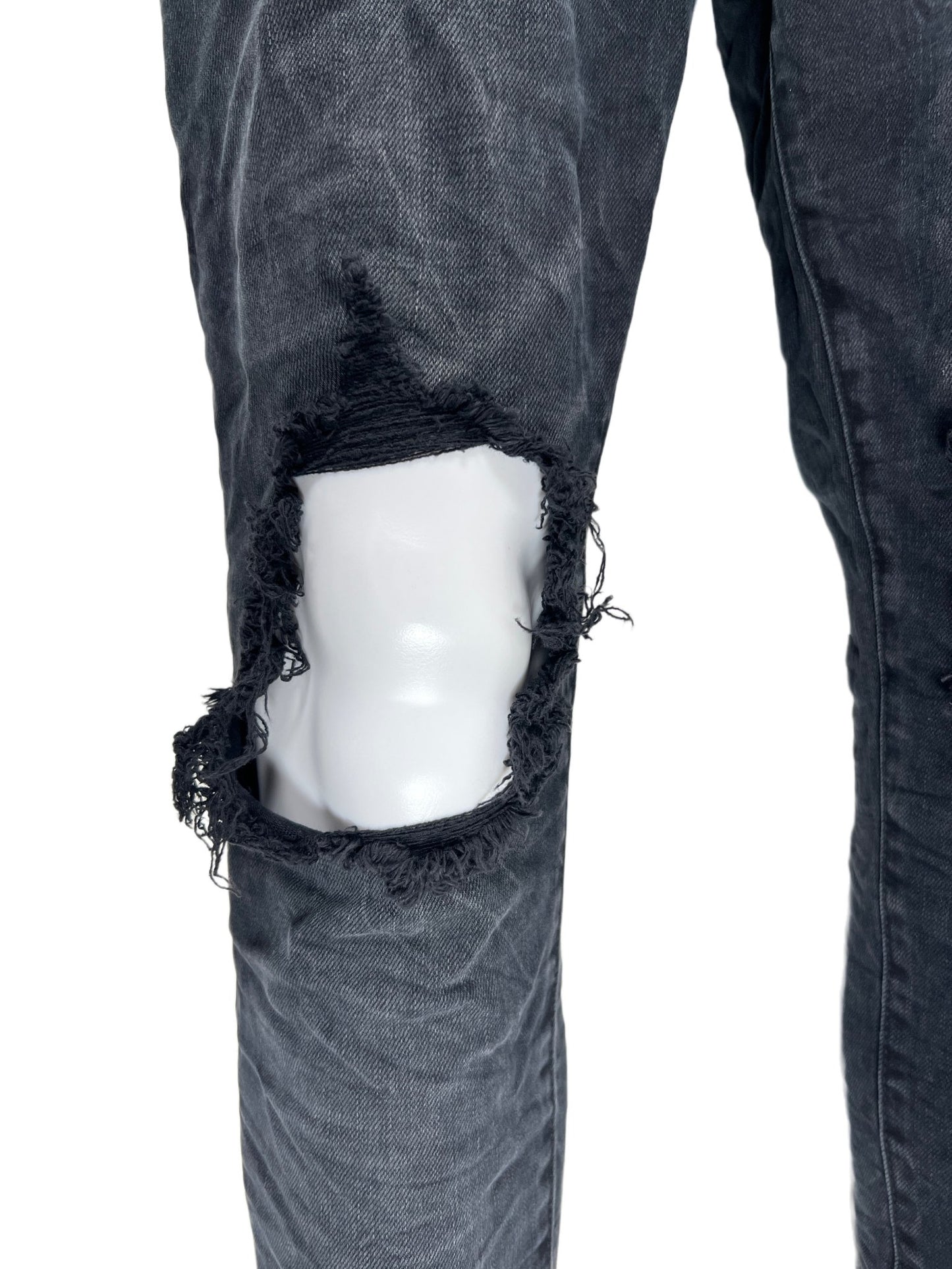 A pair of PURPLE BRAND jeans with ripped knees.