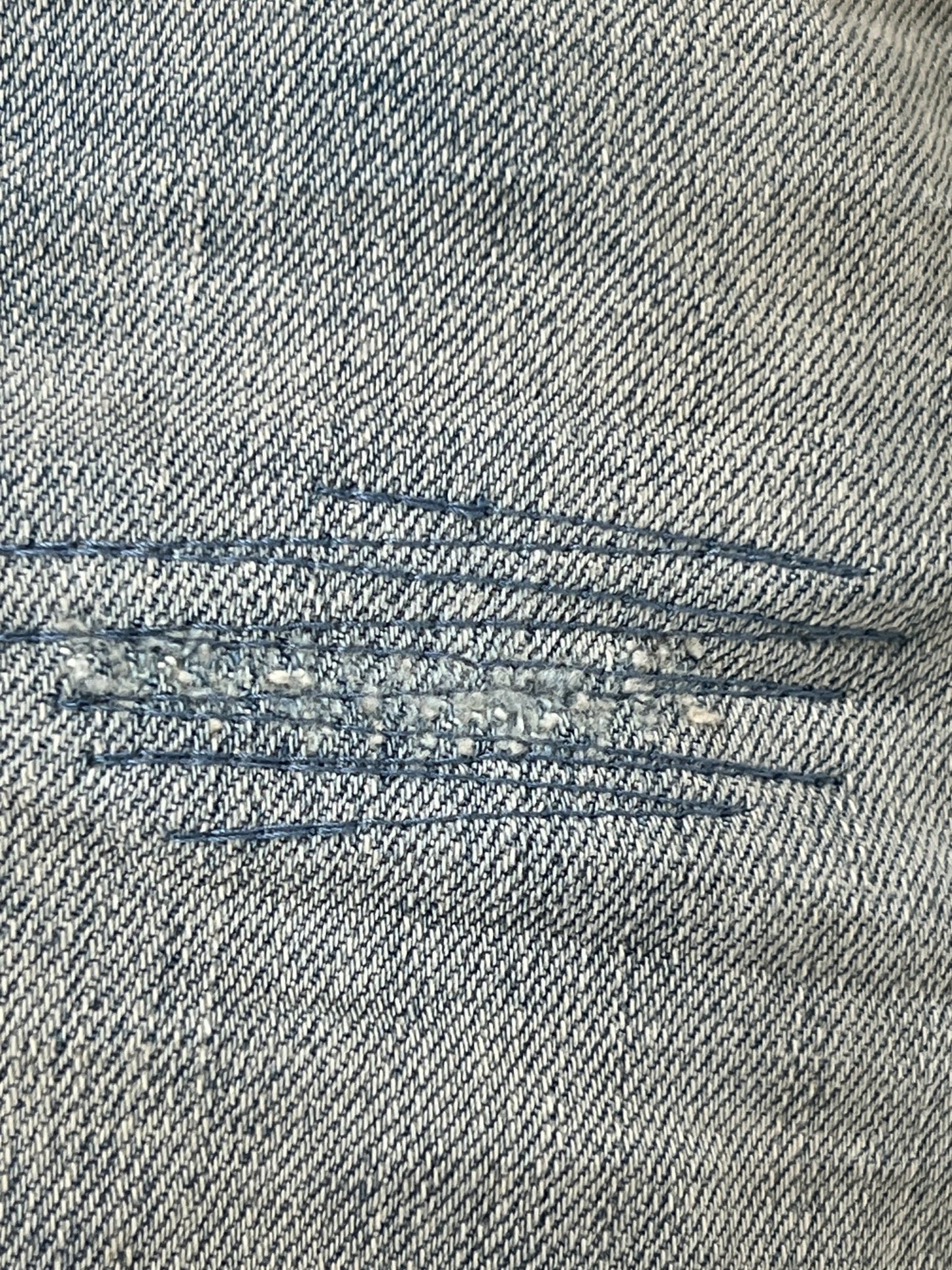 A close up of a pair of PURPLE BRAND P004-WLIW WORN LIGHT INDIGO FLARE jeans.