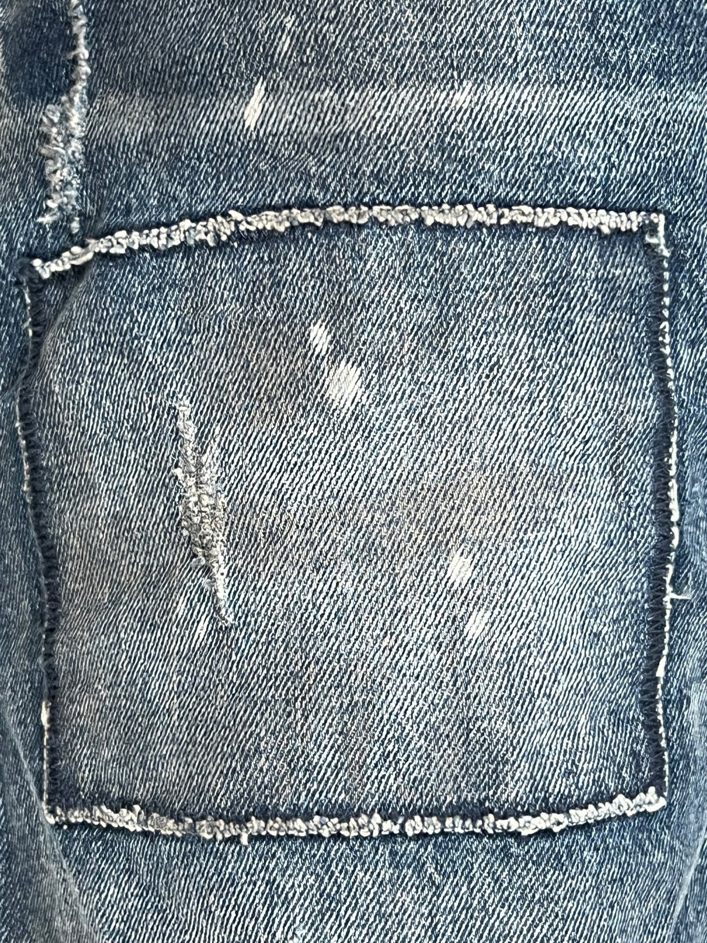 A close up of a pair of Purple Brand vintage jeans with holes in them.